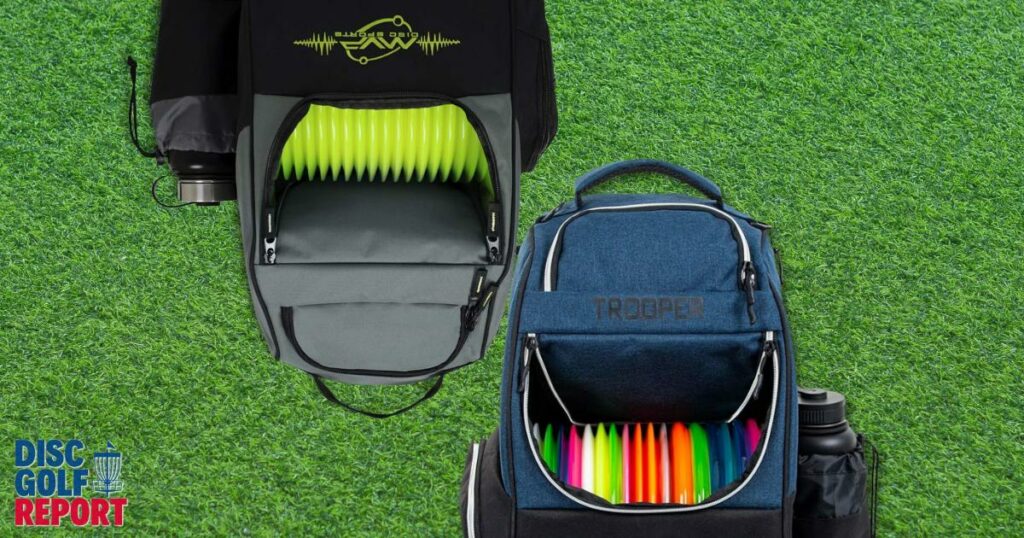 Two of the best disc golf bags positioned in the center of a grass covered background